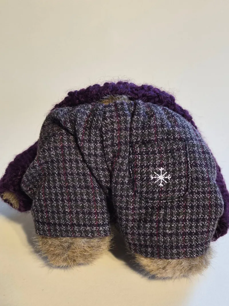 Close-up of the bear's gray houndstooth tweed trousers with a white snowflake embroidered on the back pocket