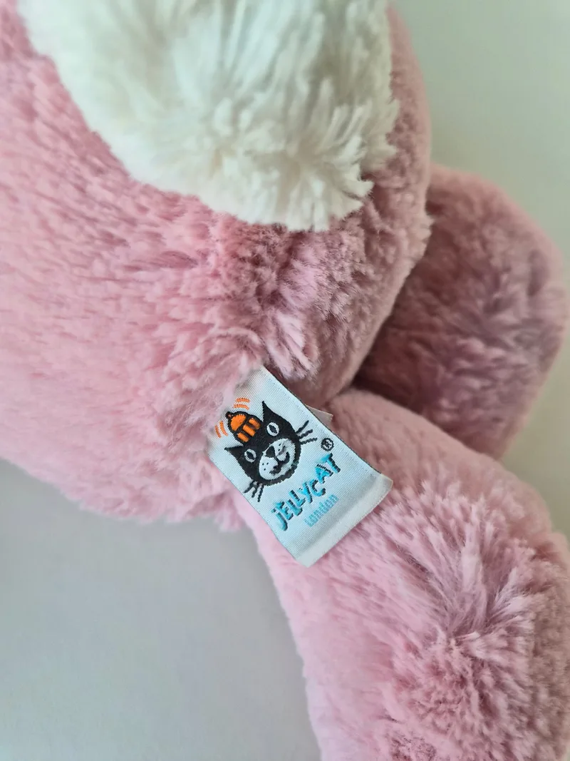 Close-up of the Jellycat London tag with black-cat logo stitched near the tail