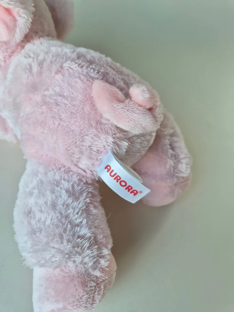 Close-up of the pig's curly tail and the red Aurora side tag stitched to the seam