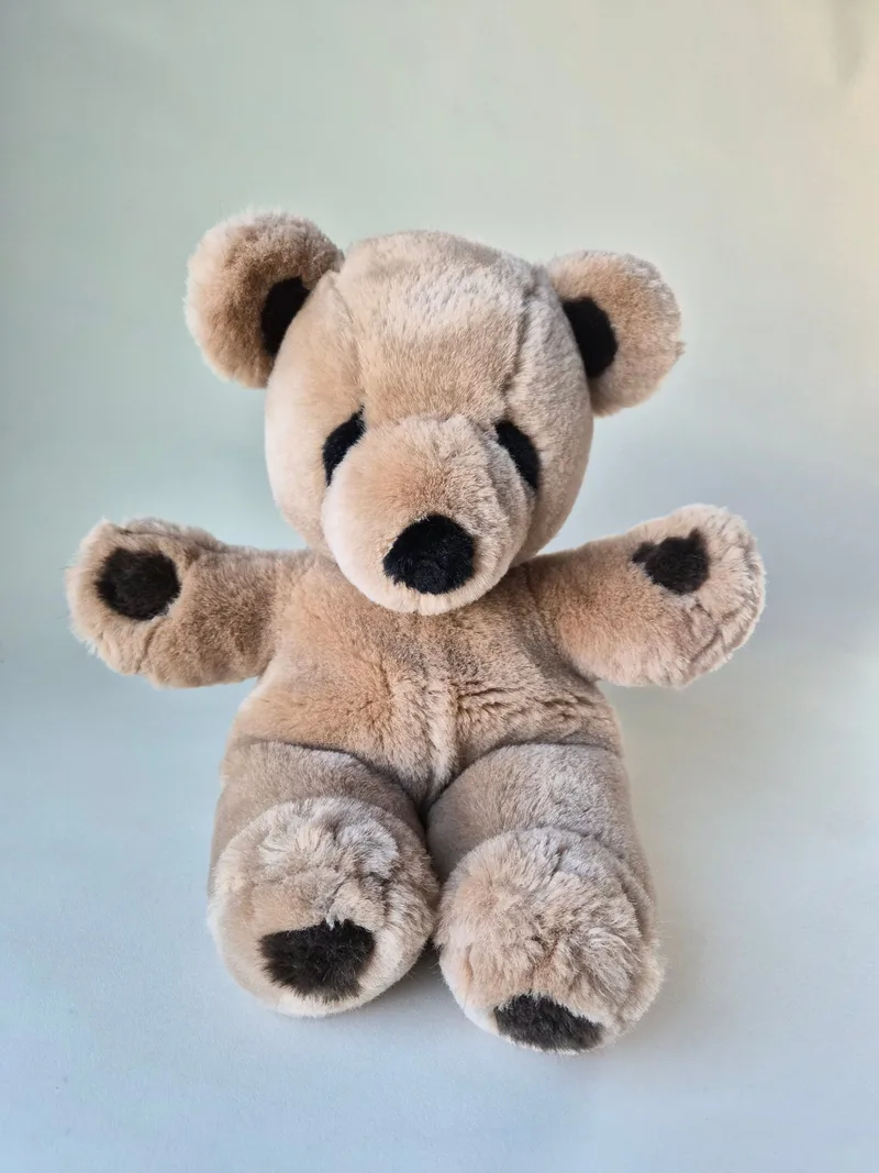 Honey-brown GUND teddy bear seated upright with chocolate suede pads on paws and feet