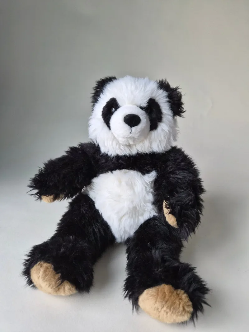 Large black-and-white Build-A-Bear panda seated with one arm raised, tan paw pads and shaggy fur