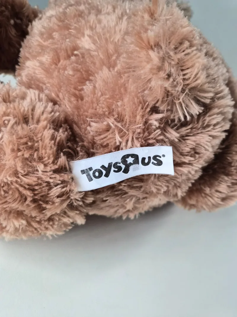 Close-up of the bear's fur showing a white Toys "R" Us side-seam label
