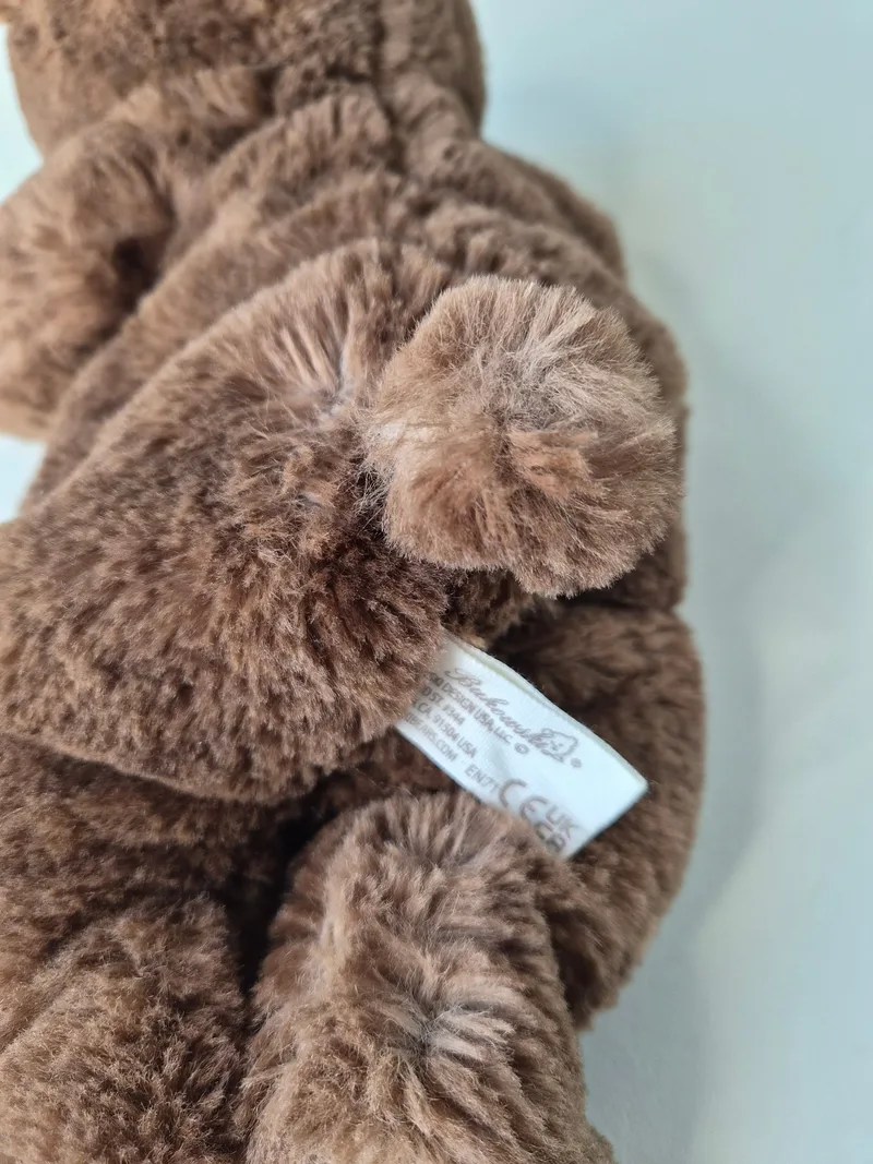 Close-up of the bear's tan suede foot-sole with a woven Bukowski maker's tag