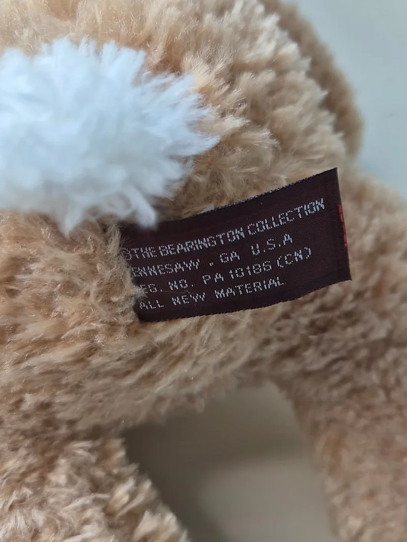 Close-up of the brown Bearington Collection fabric tag stitched into the bunny's seam