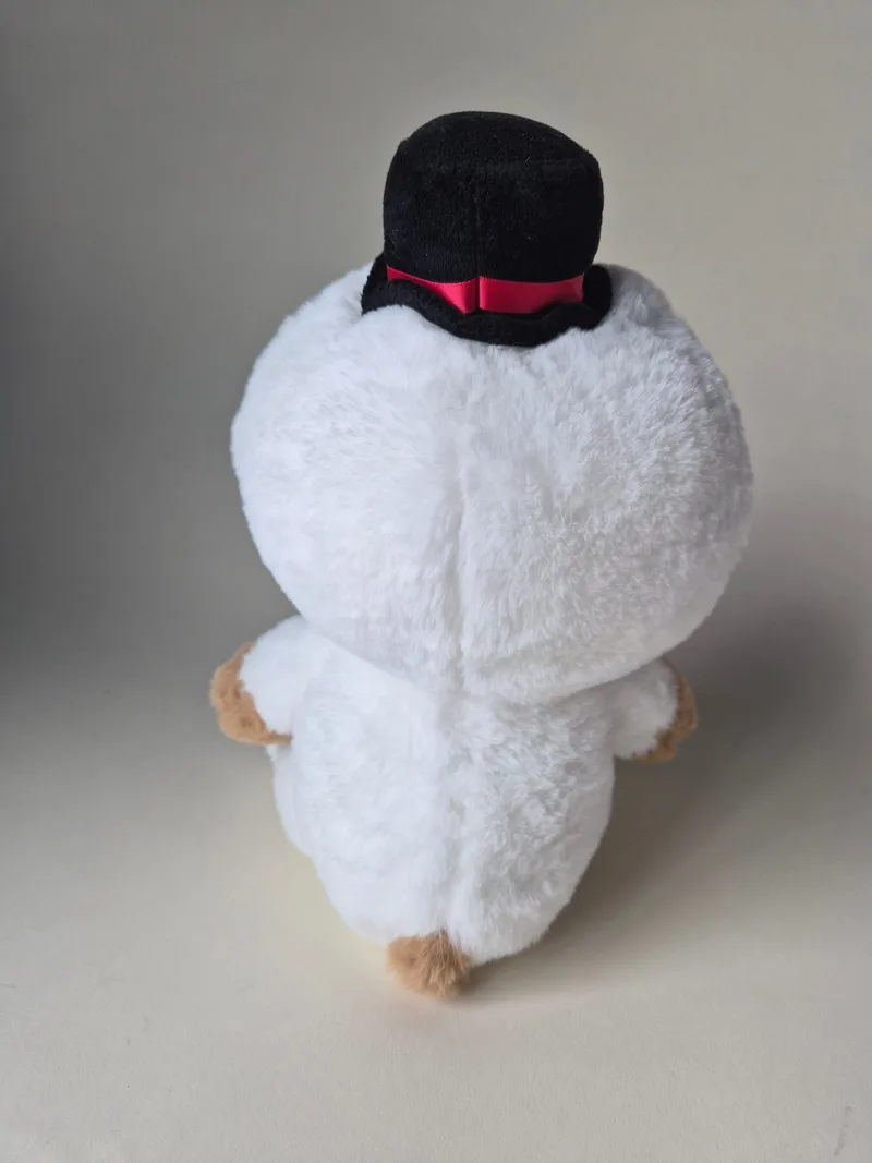 Back view of the bear in the white snowman suit, showing the top hat's red ribbon bow and brown paw peeking out