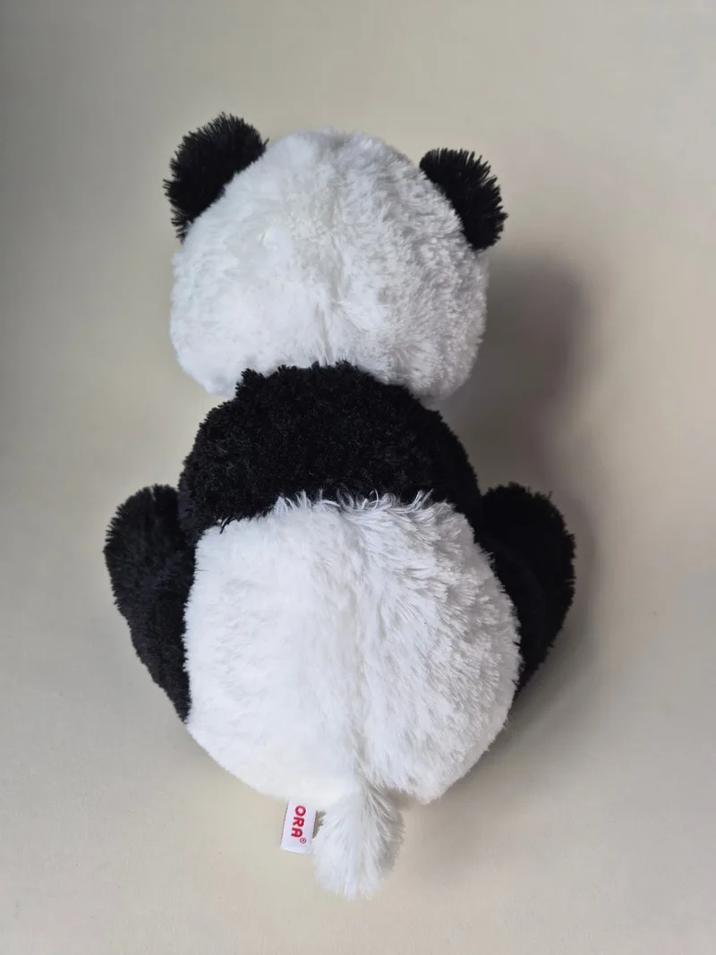 Back view of the panda plush showing its rounded ivory rump and a red Aurora seam tag at the base