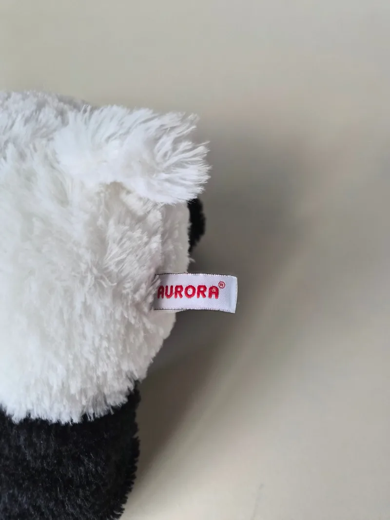 Close-up of the panda's white shag with a red woven Aurora brand tag along the seam