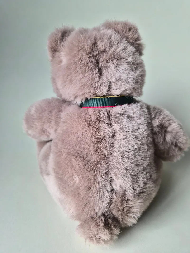 Back view of the taupe teddy bear showing full plush fur and the tartan ribbon tied behind the neck