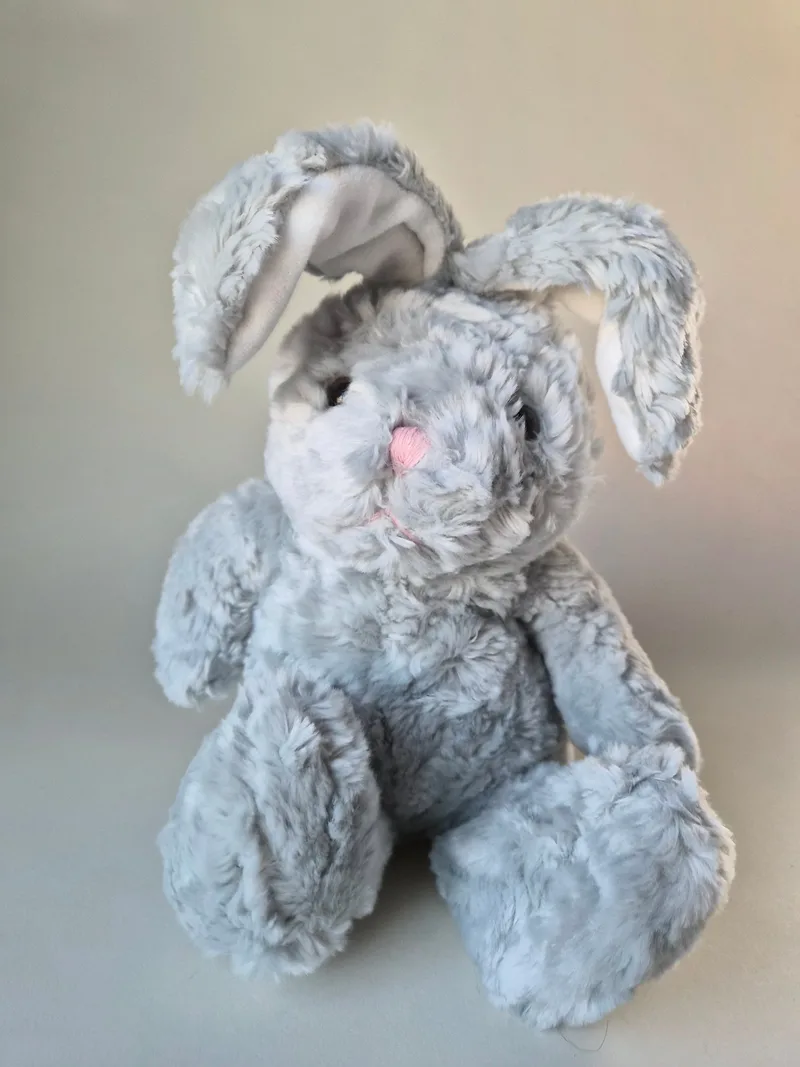 Front view of a dove-grey plush rabbit with long cream-lined ears and dark bead eyes