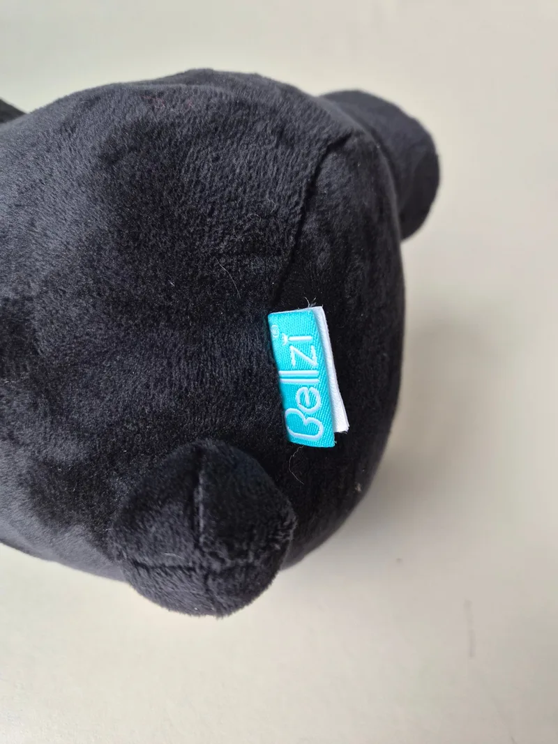 Close-up of the teal woven Bellzi tag sewn into the bear's hip seam
