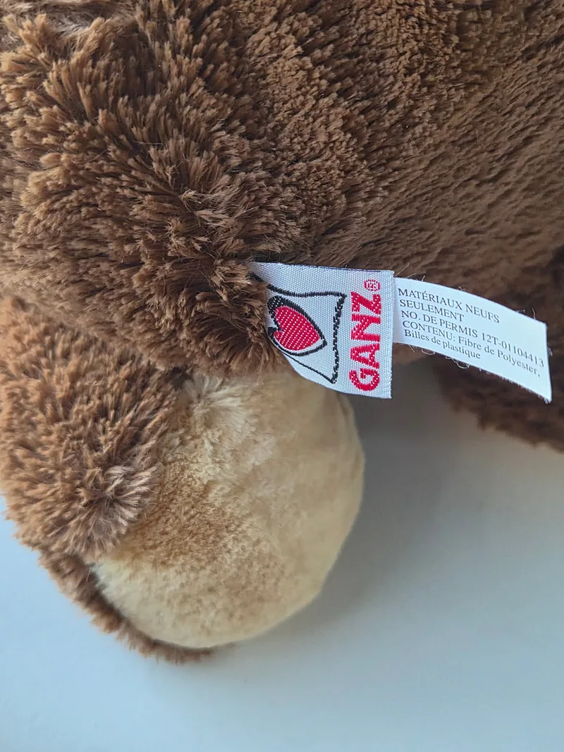 Close-up of the red GANZ heart tag stitched at the bear's hip