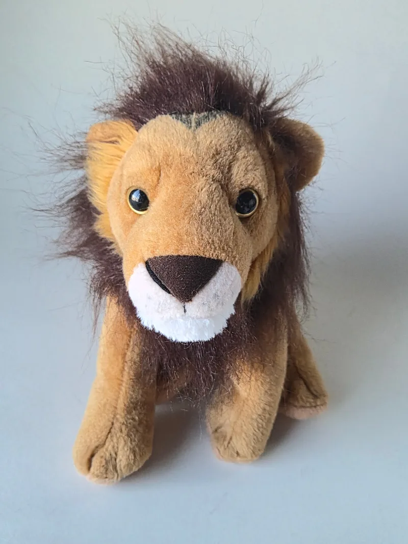 Front view of a golden-tan plush lion with a deep brown mane, ivory muzzle and amber eyes, sitting upright
