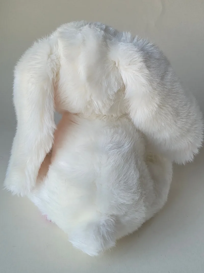Back view of the cream bunny showing long ears folded forward, faint ivory toning and lightly pressed fur along the spine