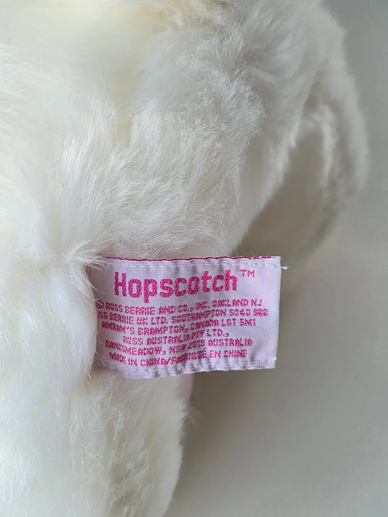 Close-up of the bunny's woven label reading Hopscotch in pink thread, with Russ Berrie and Co., Oakland NJ printed beneath
