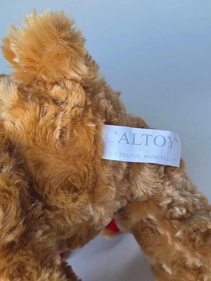 White Caltoy label reading MADE TO LOVE, MADE TO LAST stitched into the bear's side seam