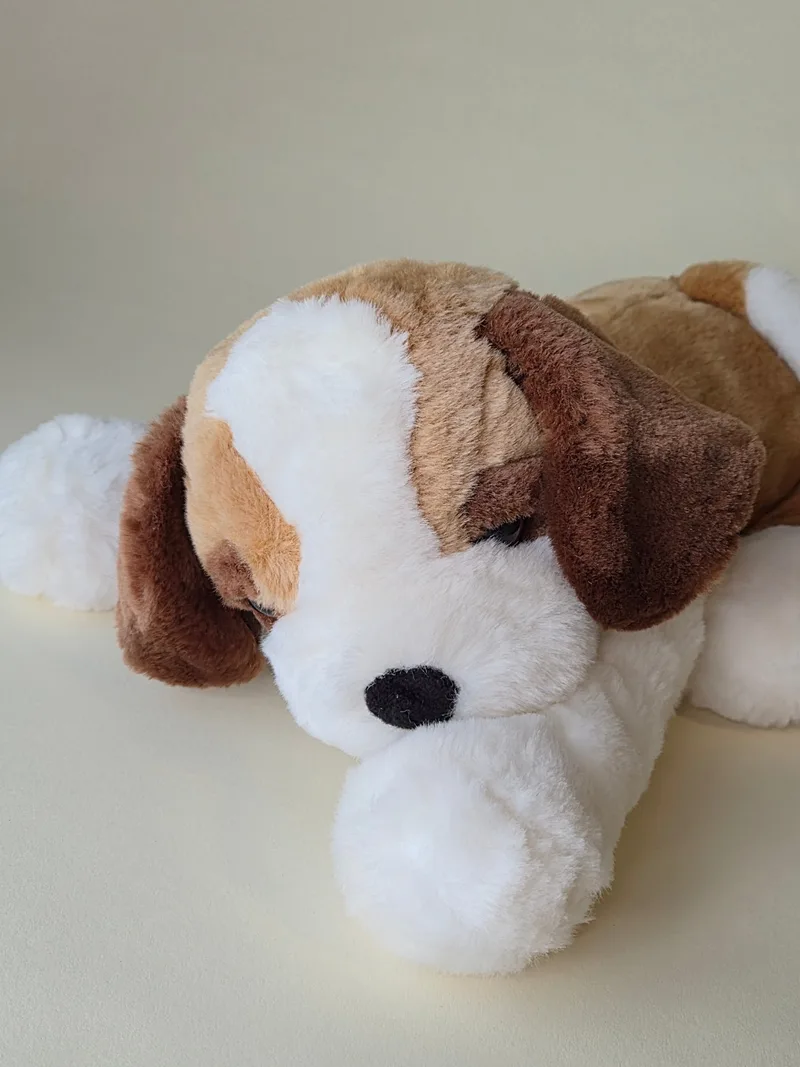 Close-up of the puppy's sleepy stitched face and round black velour nose