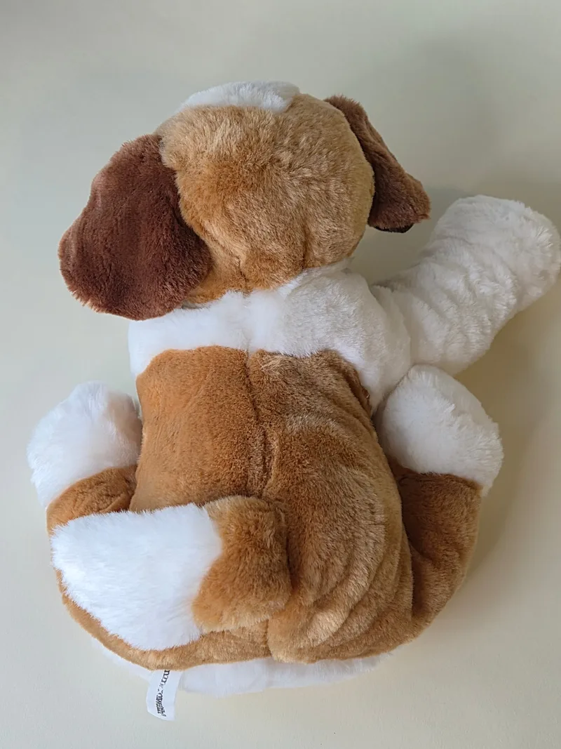 Back view showing the honey and white plush and a small hem tag on the lower flank