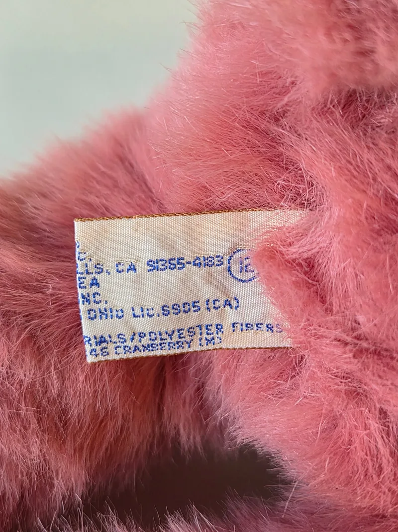 Close-up of a second woven tag naming cranberry shade and polyester fill