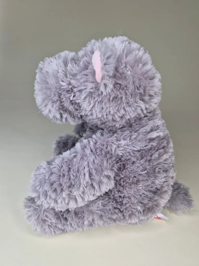 Side profile of the grey plush bear showing the curve of its back and folded ear