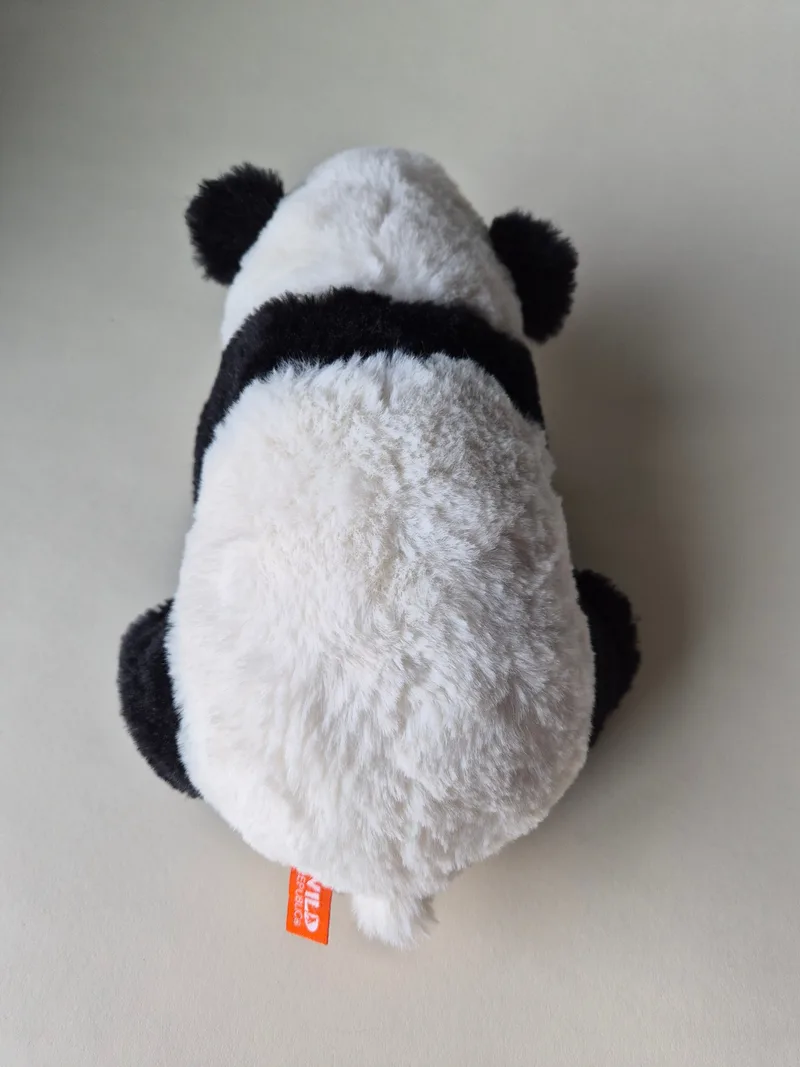 Overhead view of the panda's back and rounded ears, showing an orange Wild Republic tag stitched near the tail