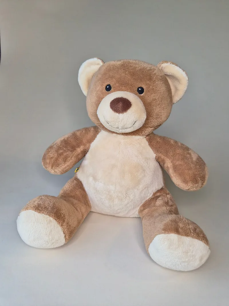 Seated tan and cream teddy bear with embroidered brown nose and black eyes, front view