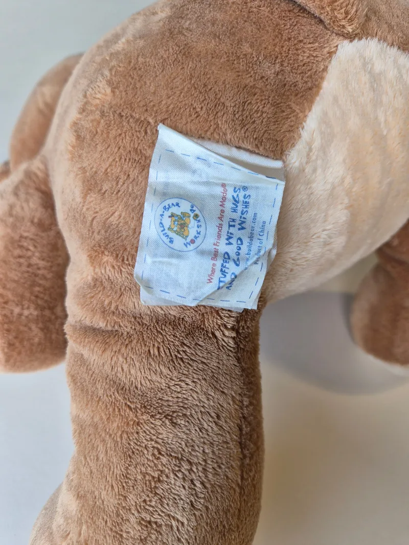 Close-up of the Build-A-Bear Workshop fabric tag stitched into the bear's hip seam